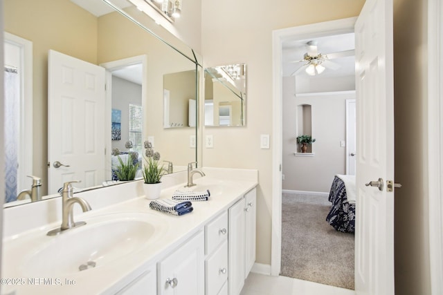 full bath with a sink, baseboards, ceiling fan, and double vanity