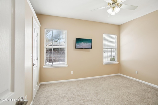 spare room with a ceiling fan, carpet, and baseboards