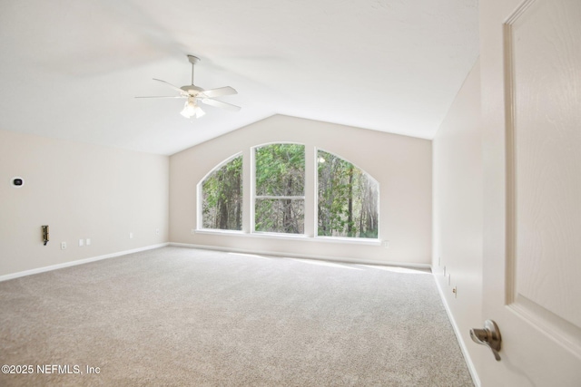 spare room featuring vaulted ceiling, a ceiling fan, baseboards, and carpet floors