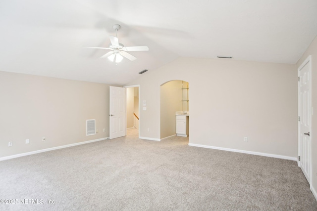 unfurnished bedroom featuring vaulted ceiling, baseboards, visible vents, and light carpet