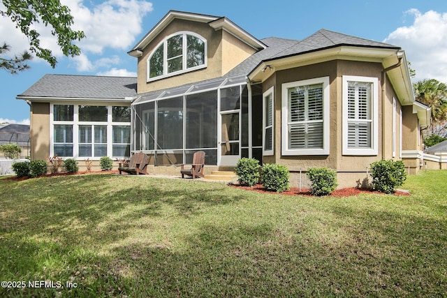 back of house with a yard, a sunroom, and stucco siding