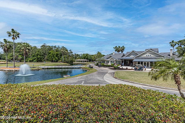 view of home's community featuring a yard, a water view, and a patio area