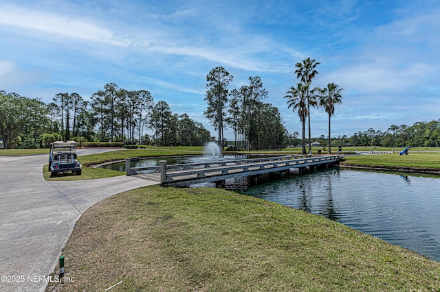 dock area with a water view and a lawn