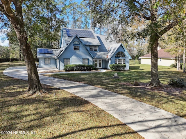 view of front of house featuring solar panels and a front yard