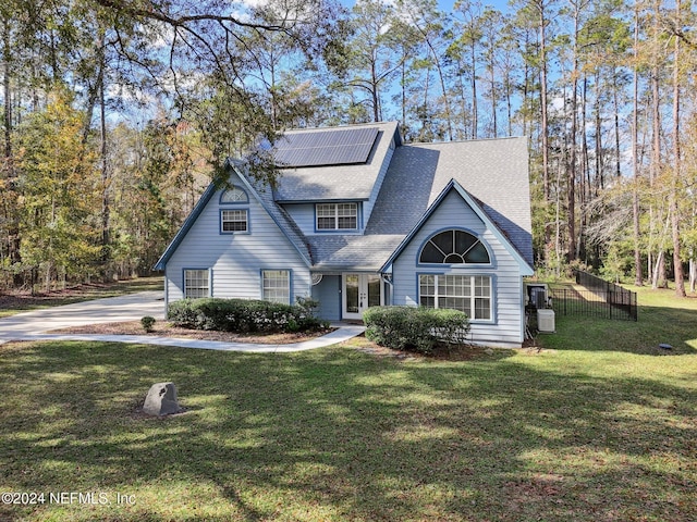 view of front of house with solar panels, a front yard, and french doors