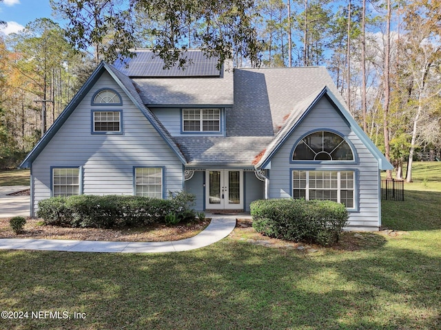 view of front of house featuring a front yard, french doors, and solar panels