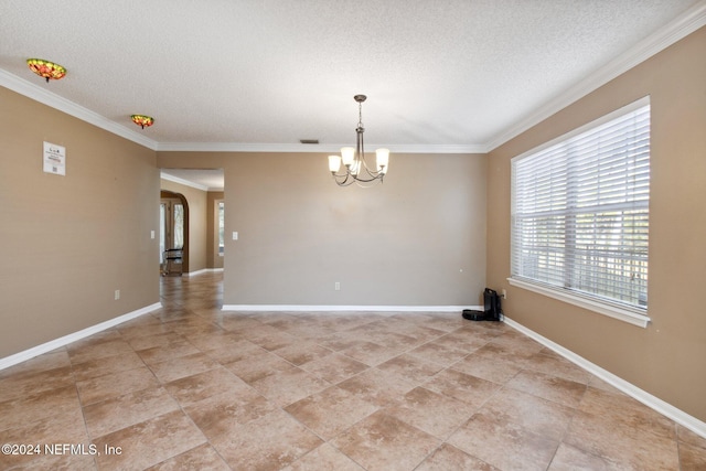 spare room with ornamental molding, a textured ceiling, and a chandelier