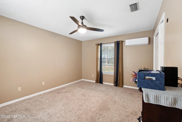 carpeted bedroom with a textured ceiling, an AC wall unit, and ceiling fan