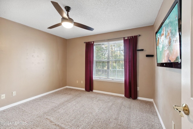 carpeted empty room with a textured ceiling and ceiling fan