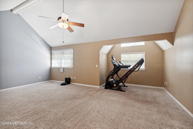 workout room with ceiling fan, plenty of natural light, carpet, and lofted ceiling