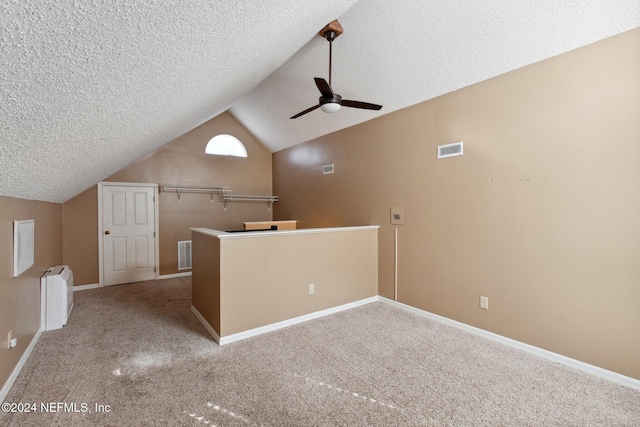 additional living space with carpet flooring, radiator, ceiling fan, a textured ceiling, and lofted ceiling