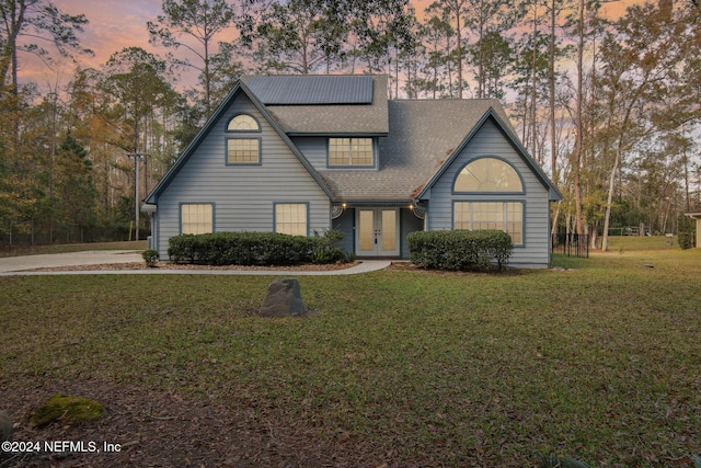 view of front facade featuring a lawn and french doors