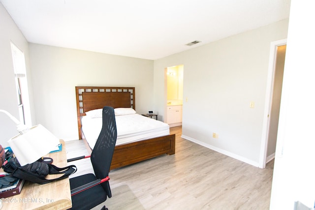 bedroom featuring light hardwood / wood-style floors and connected bathroom