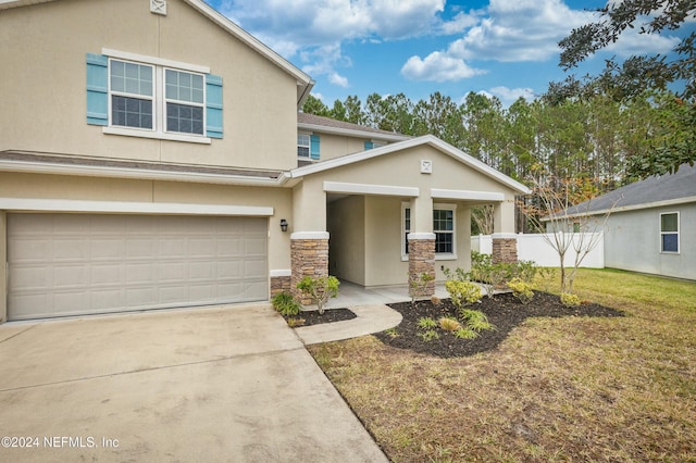 view of front of house with a front lawn, covered porch, and a garage