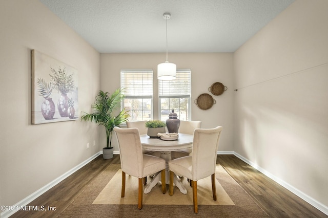 dining area featuring a textured ceiling and dark wood-type flooring