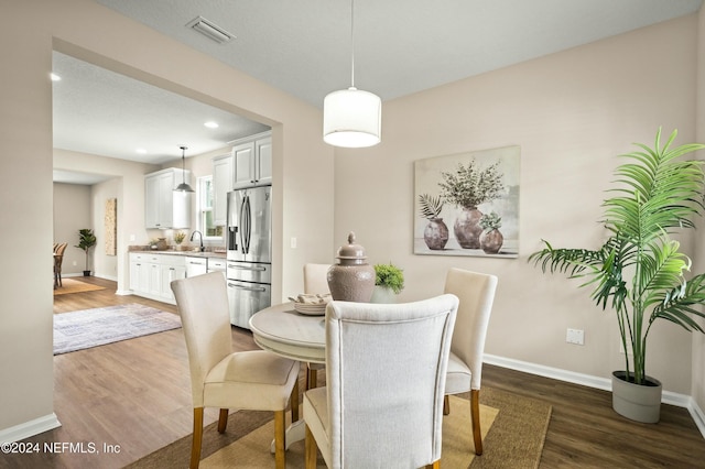 dining space featuring hardwood / wood-style floors and sink