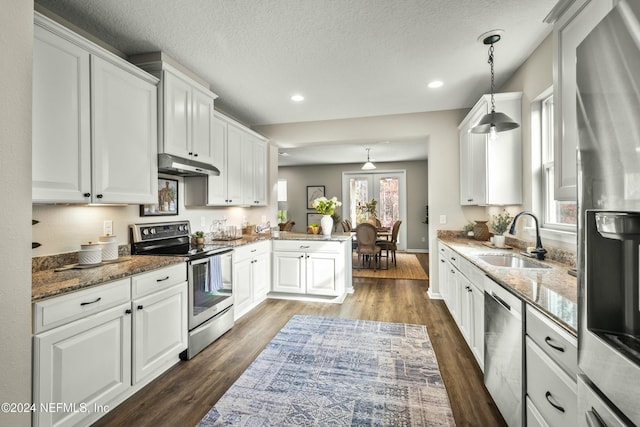 kitchen featuring white cabinetry, sink, stainless steel appliances, kitchen peninsula, and pendant lighting