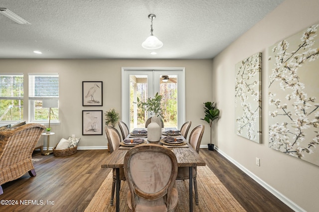 dining area featuring a textured ceiling, dark hardwood / wood-style flooring, and a wealth of natural light