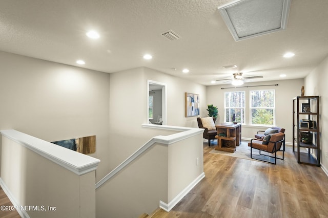 hall with wood-type flooring and a textured ceiling