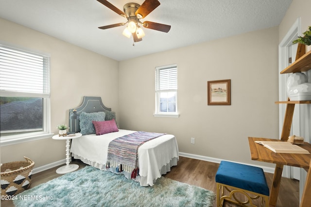 bedroom featuring a textured ceiling, dark hardwood / wood-style floors, and ceiling fan