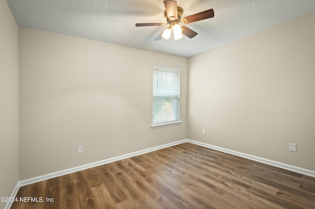 unfurnished room with ceiling fan, dark hardwood / wood-style flooring, and a textured ceiling