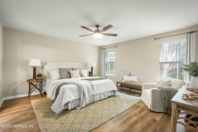 bedroom featuring a textured ceiling, light hardwood / wood-style flooring, and ceiling fan