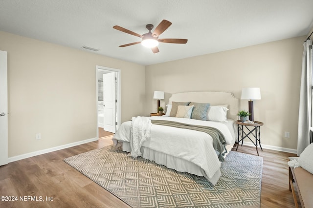 bedroom featuring ensuite bathroom, ceiling fan, and wood-type flooring