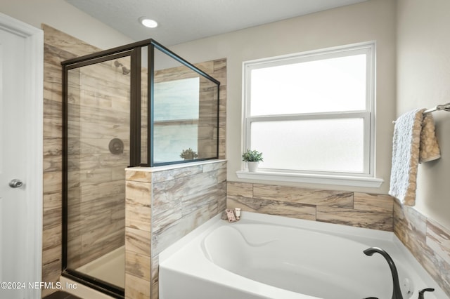 bathroom featuring separate shower and tub