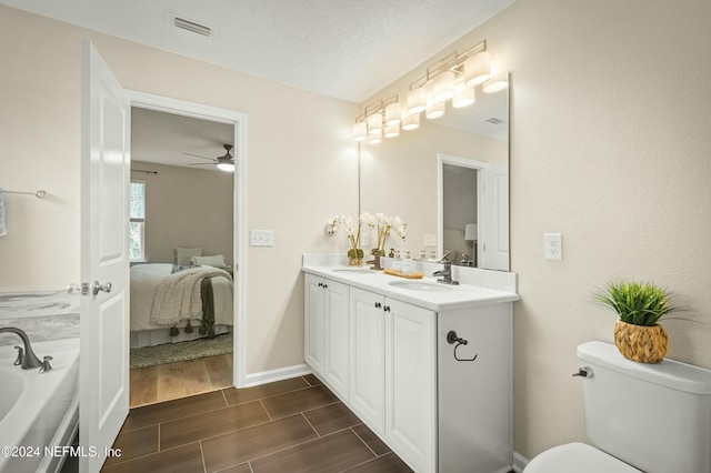 bathroom featuring hardwood / wood-style floors, vanity, ceiling fan, toilet, and a textured ceiling