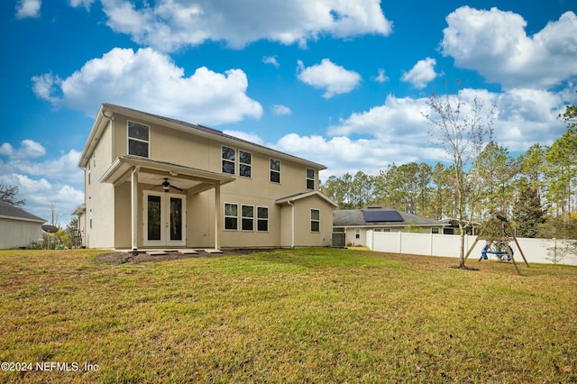 back of property with french doors, a yard, a playground, and cooling unit