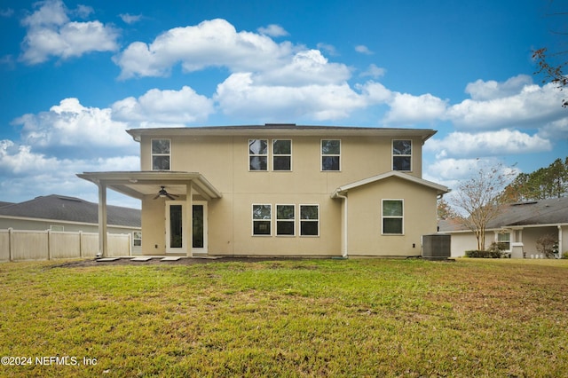 rear view of property with a lawn, ceiling fan, and central air condition unit