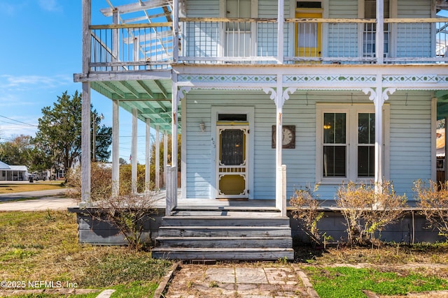 view of exterior entry featuring a balcony