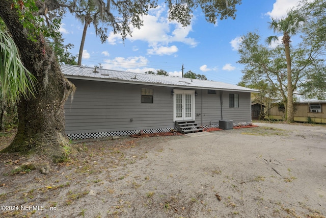 rear view of property with french doors and cooling unit