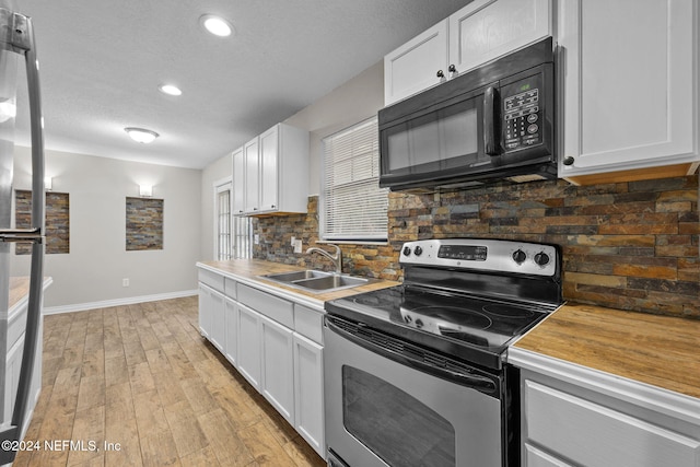 kitchen featuring sink, white cabinets, stainless steel range with electric stovetop, and light wood-type flooring