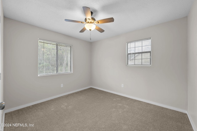 empty room with a textured ceiling, carpet floors, and ceiling fan