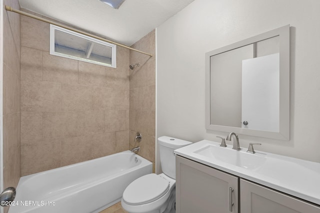 full bathroom featuring vanity, a textured ceiling, tiled shower / bath combo, and toilet