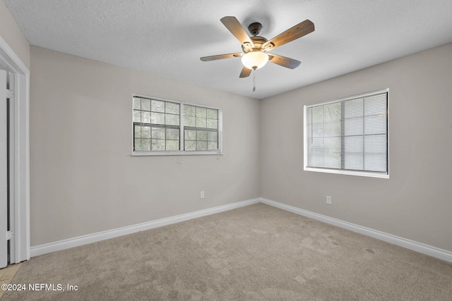 carpeted spare room with ceiling fan and a textured ceiling