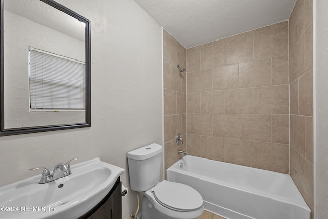 full bathroom with vanity, tiled shower / bath combo, a textured ceiling, and toilet