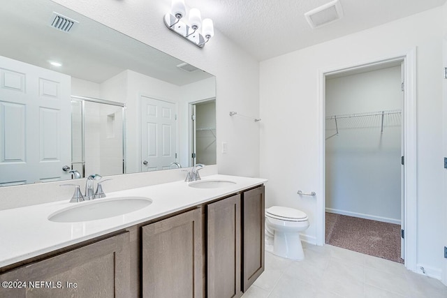 bathroom featuring walk in shower, tile patterned flooring, a textured ceiling, toilet, and vanity