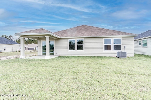 back of house featuring a lawn, a patio area, and central AC