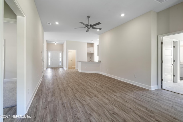 unfurnished living room featuring wood-type flooring and ceiling fan