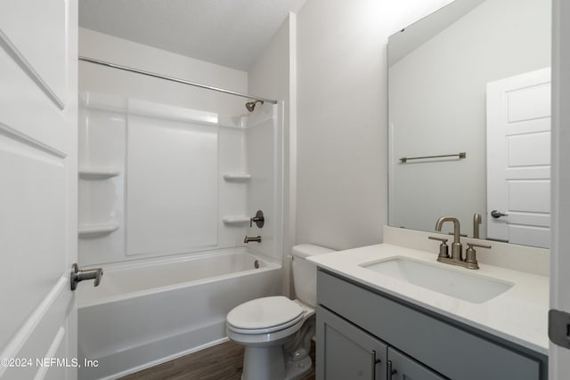 full bathroom with hardwood / wood-style floors, vanity, a textured ceiling, shower / bathtub combination, and toilet