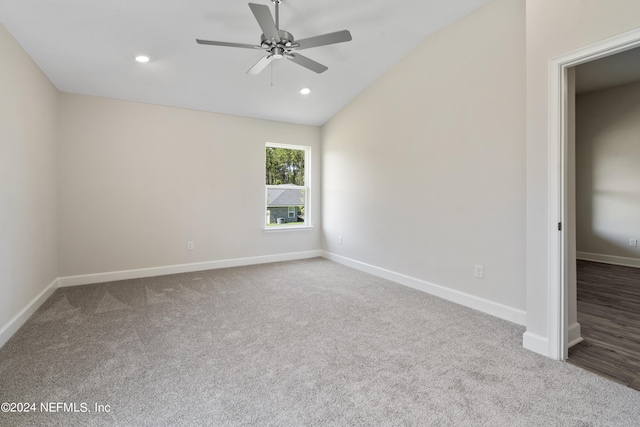 empty room with vaulted ceiling, ceiling fan, and carpet