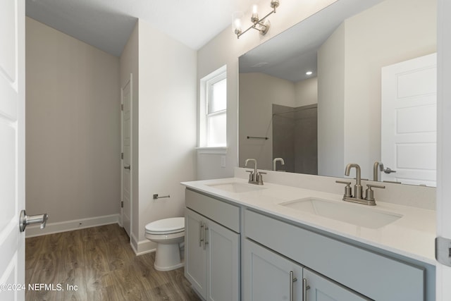 bathroom with walk in shower, vanity, toilet, and hardwood / wood-style floors