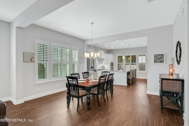 dining area featuring dark hardwood / wood-style floors and a notable chandelier