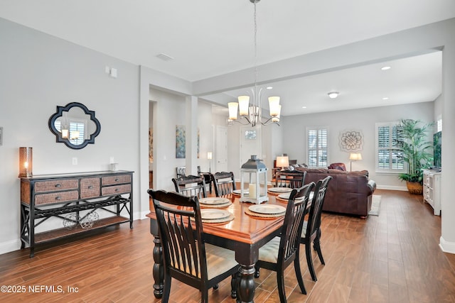 dining space with hardwood / wood-style flooring and an inviting chandelier