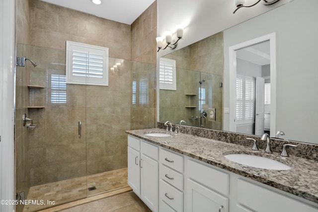 bathroom with tile patterned flooring, vanity, an enclosed shower, and a healthy amount of sunlight