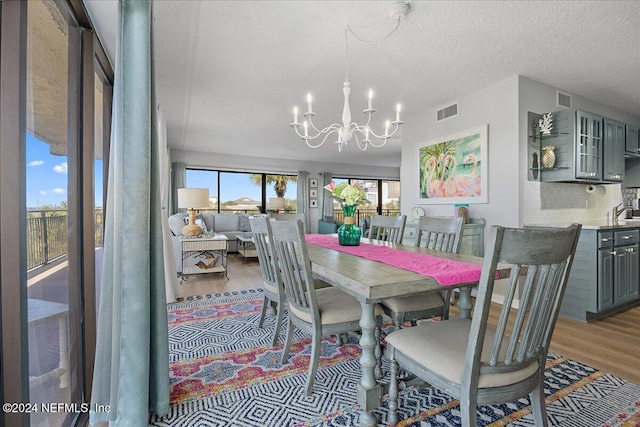 dining space featuring a textured ceiling, a notable chandelier, and hardwood / wood-style flooring