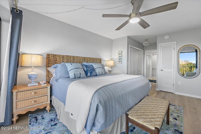 bedroom with hardwood / wood-style flooring, ceiling fan, and ensuite bath