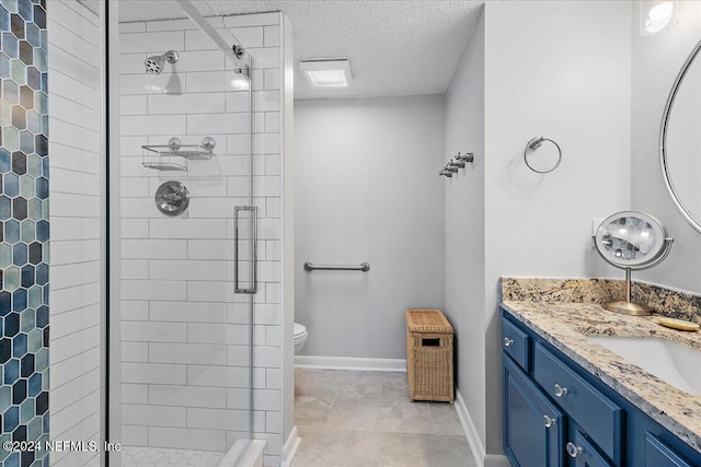 bathroom with tile patterned floors, a textured ceiling, tiled shower, toilet, and vanity